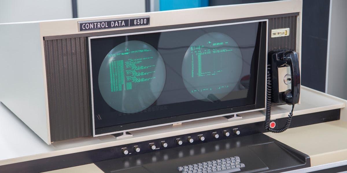 A close-up of the control panel. Two circular screens displaying green text, with several knobs below them, what appears to be a telephone to their right, and a keyboard below them