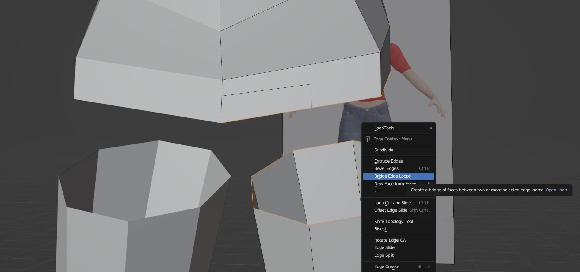 With the top of the legs and the bottom of the body selected, a context menu has popped up, and the Bridge Edge Loops option is highlighted. The description says Create a bridge of faces between two or more selected edge loops